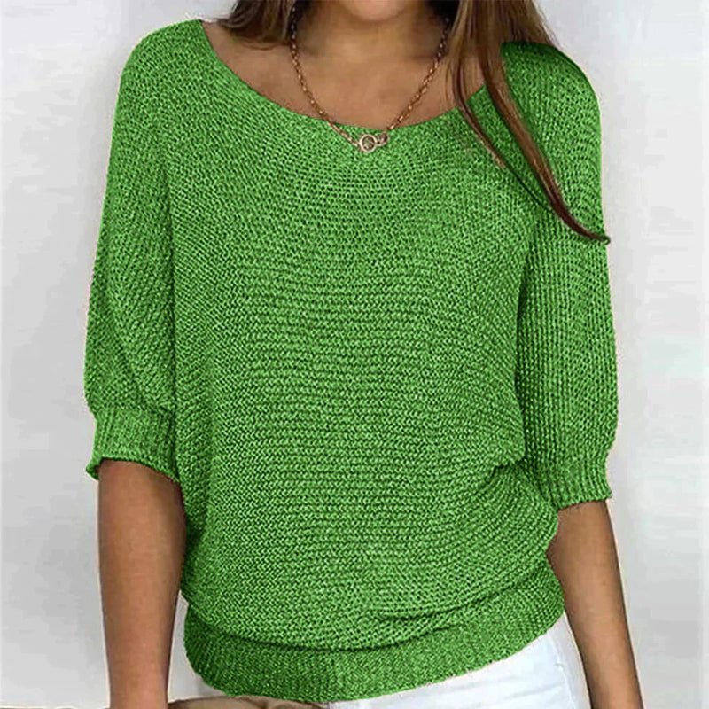 Green knitted sweater worn by a person on a white background