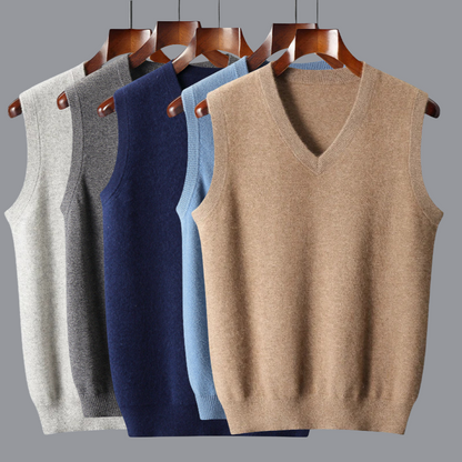 Four sweater vests in gray, blue, and beige on hangers against a gray background