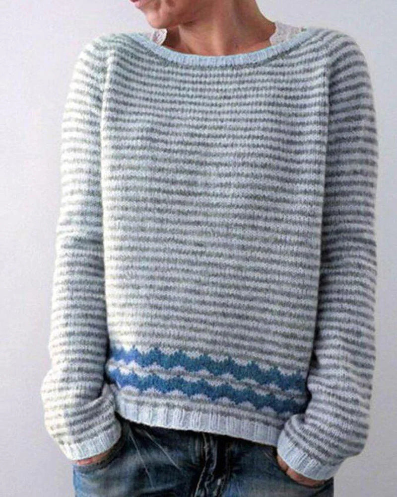 Person wearing a blue and gray striped sweater against a white background