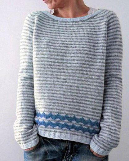 Person wearing a blue and gray striped sweater against a white background