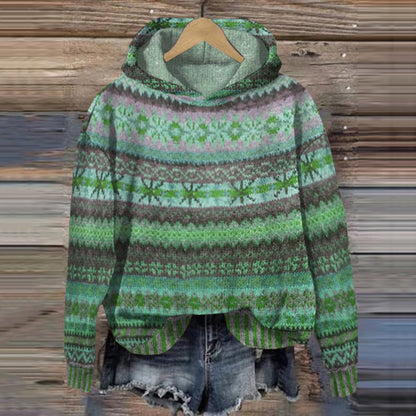 Green patterned hoodie on a wooden hanger against a wooden background