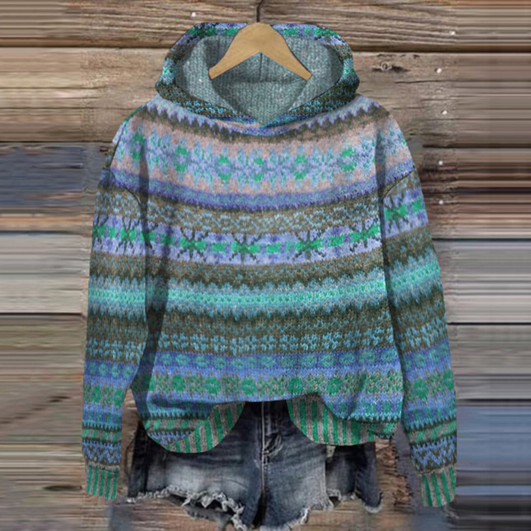 Colorful patterned sweater on a wooden hanger against a wooden background