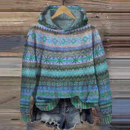 Colorful patterned sweater on a wooden hanger against a wooden background