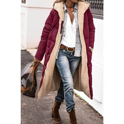 Person wearing a burgundy puffer coat with beige fur lining, blue jeans, and brown boots.