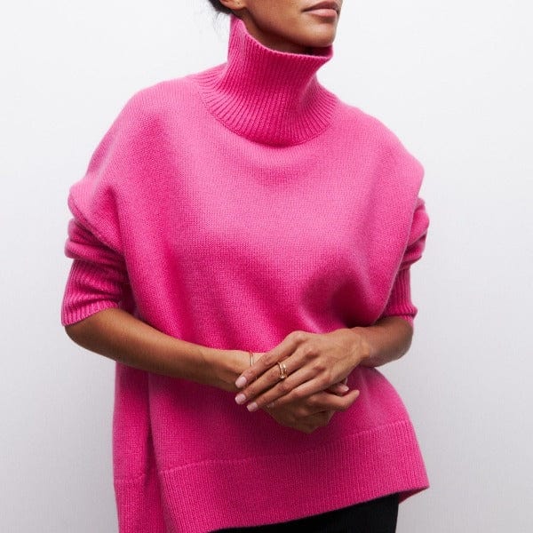 Person wearing a bright pink turtleneck sweater against a plain background