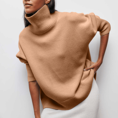 Person wearing a beige turtleneck sweater against a white background