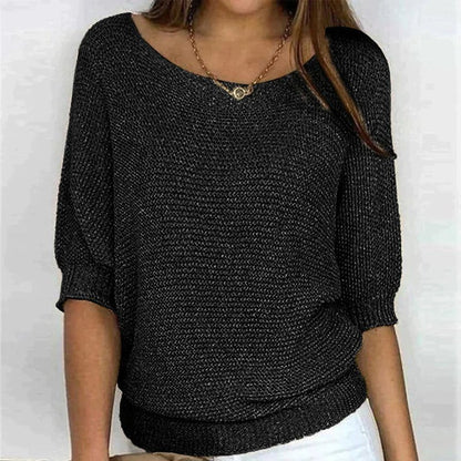 Black textured sweater worn by a person on a white background