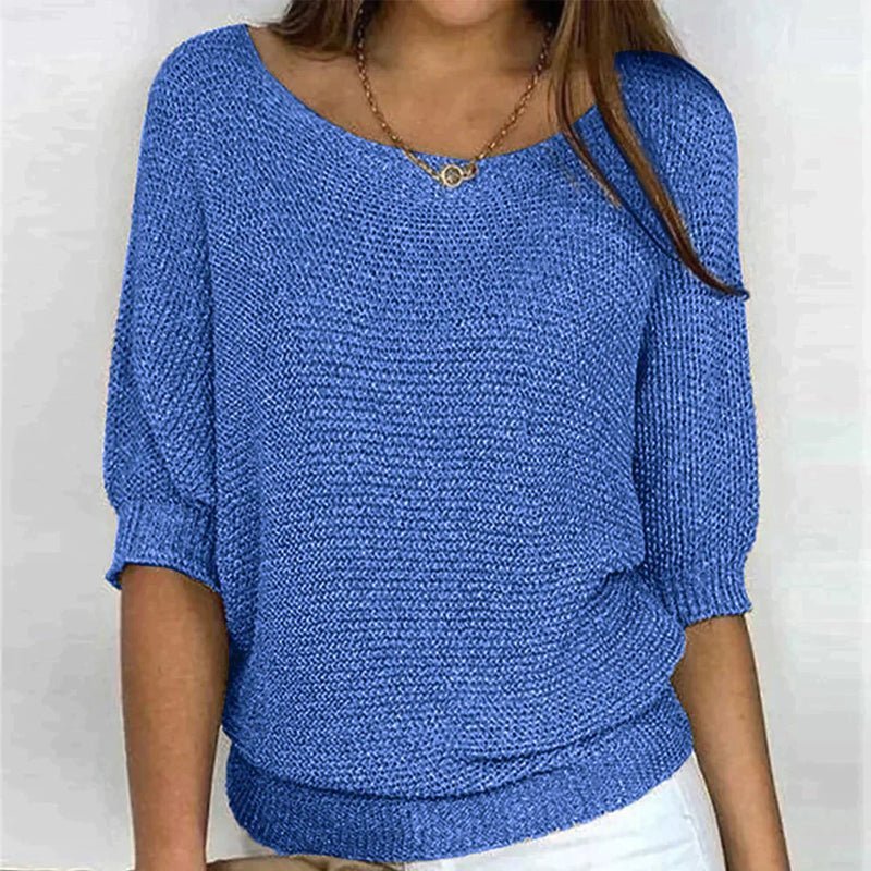 Blue knitted sweater worn by a person on a white background