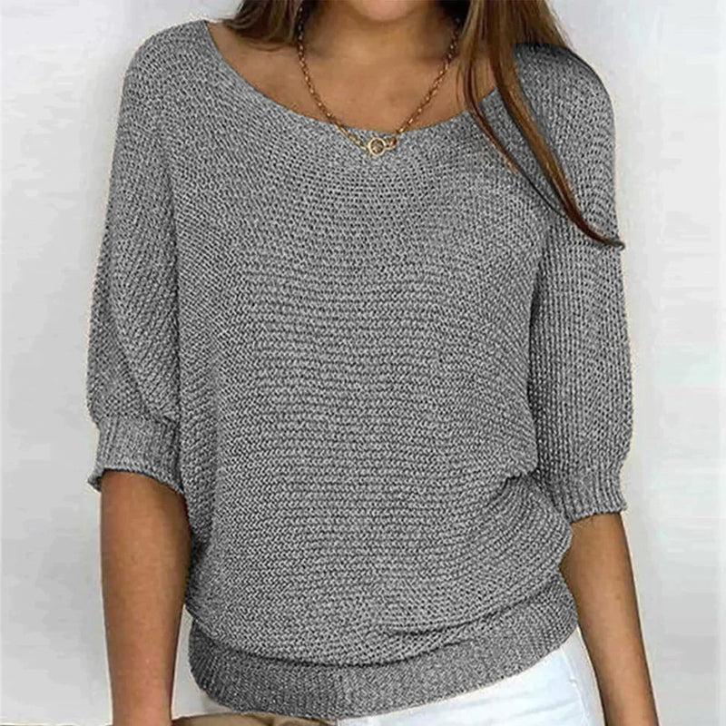 Gray knitted sweater worn by a person on a white background