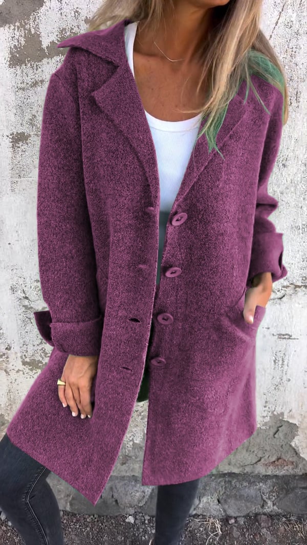 Person wearing a purple coat against a textured wall background