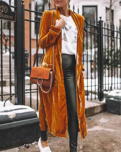 Person wearing a mustard yellow velvet coat in an urban setting
