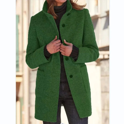 Green coat worn by a person with a blurred background