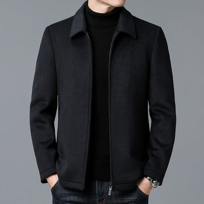 Black coat worn by a person on a gray background