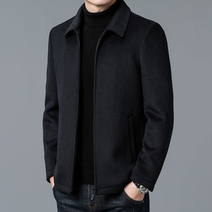 Black coat worn by a person on a gray background
