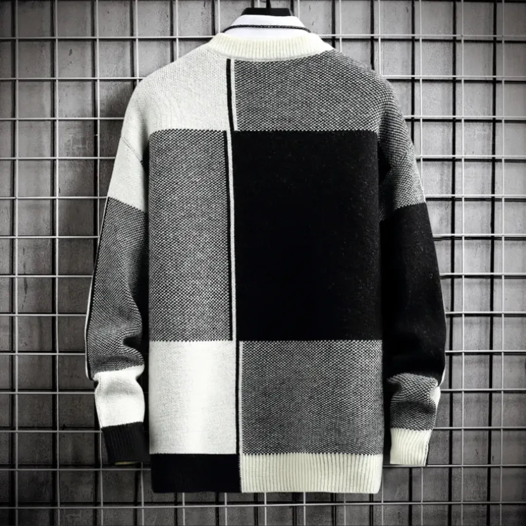 Color-blocked sweater against a grid-patterned wall