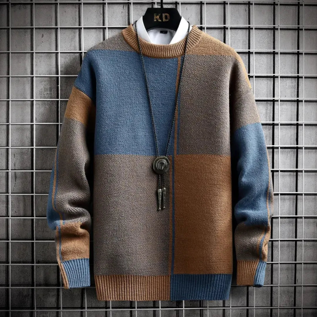Color-blocked sweater with brown, blue, and gray pattern on a grid background