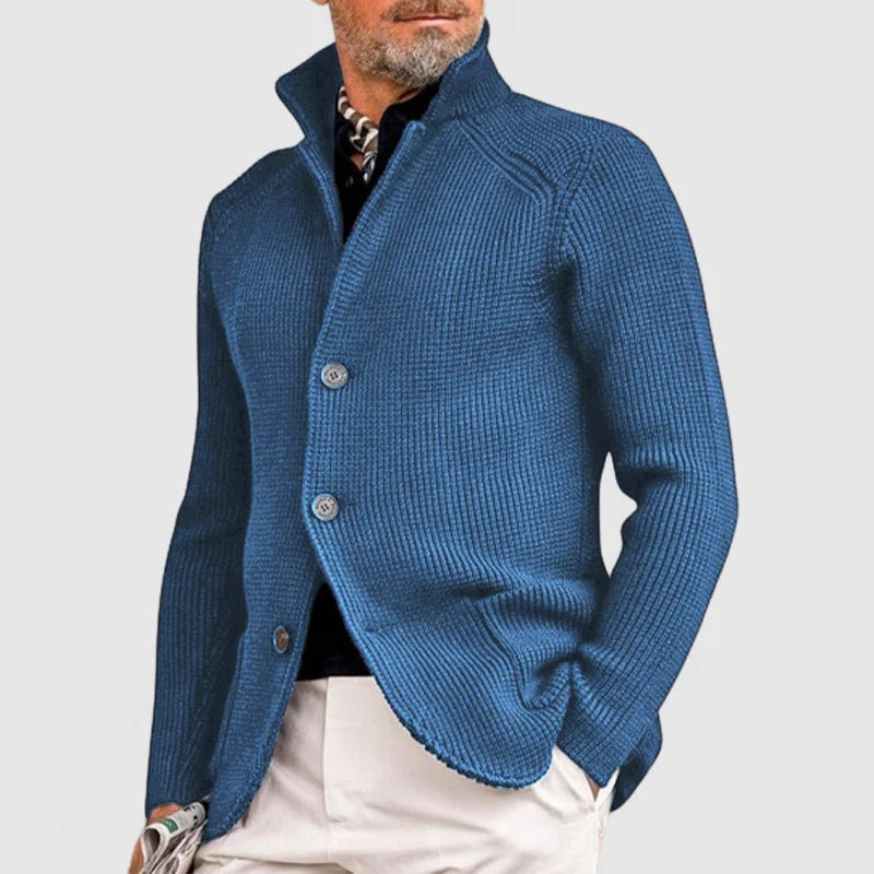 Blue knitted cardigan worn by a person on a light gray background