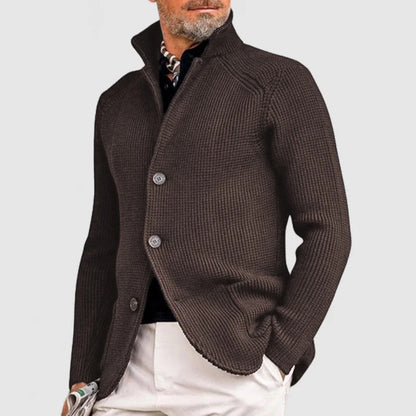 Man wearing a brown knitted cardigan on a light gray background