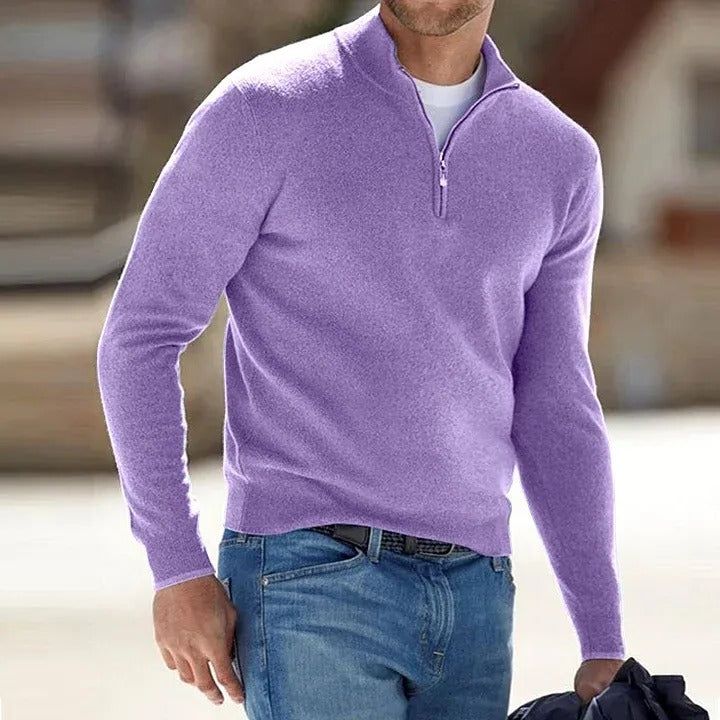 Person wearing a purple quarter-zip sweater and blue jeans outdoors.