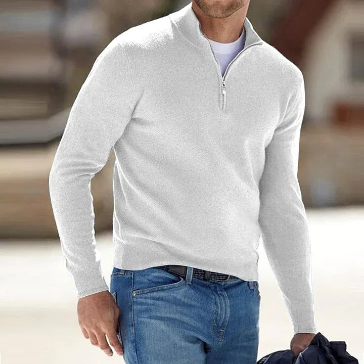 Man wearing a white long-sleeve shirt with a quarter zip and blue jeans.