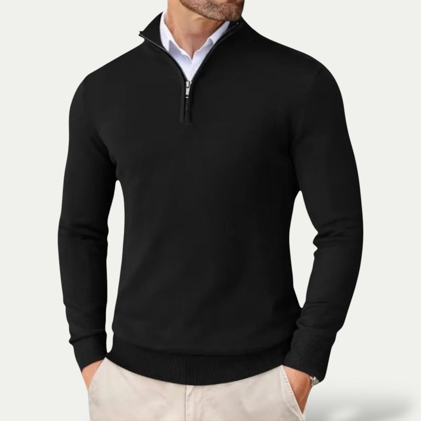 Black quarter-zip sweater worn by a person on a light gray background