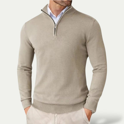 Man wearing a beige half-zip sweater on a light gray background