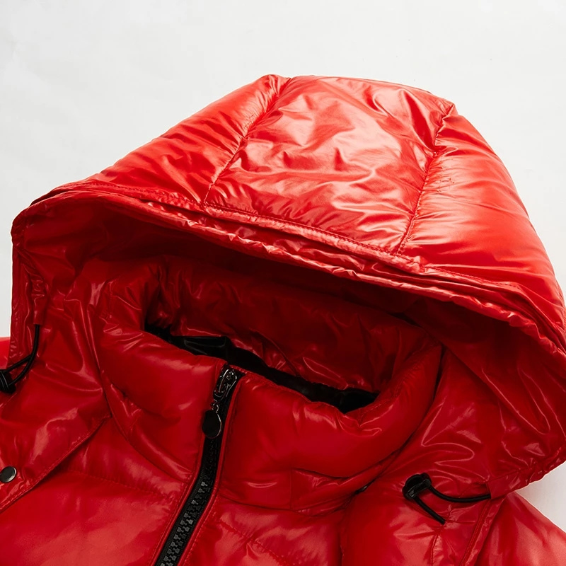 Close-up of a red puffer jacket with a hood on a light gray background