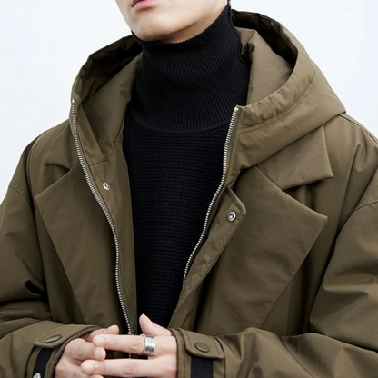 Person wearing a brown jacket over a black turtleneck on a white background