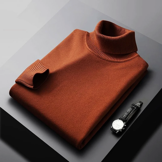 Brown turtleneck sweater on a gray surface with a watch beside it