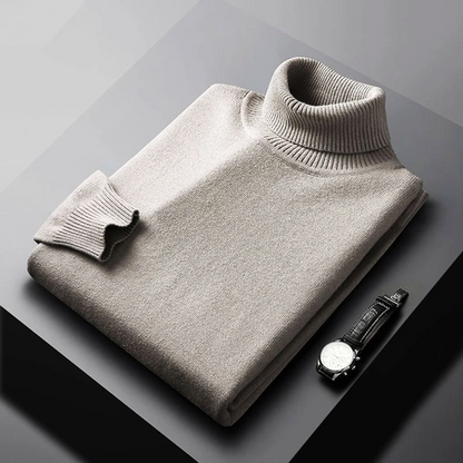 Folded gray turtleneck sweater on a dark surface with a watch beside it