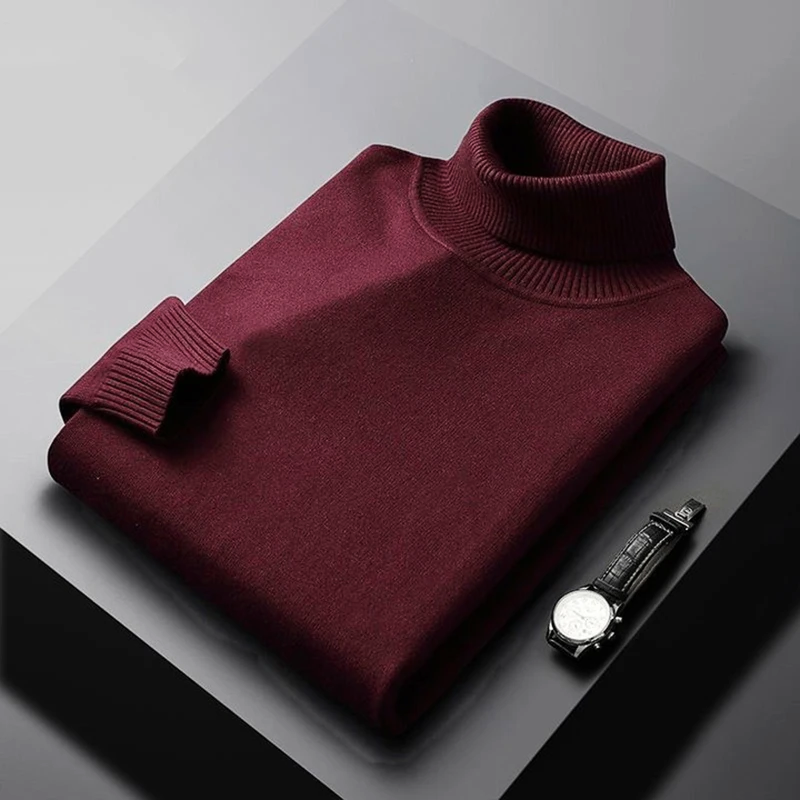 Maroon turtleneck sweater on a gray surface with a watch beside it