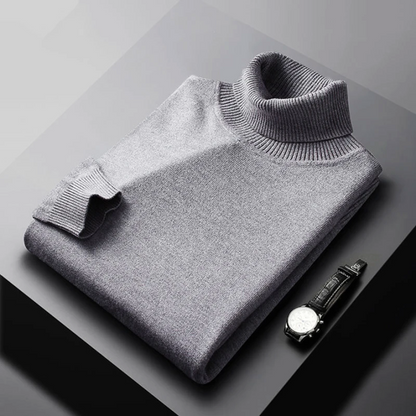 Folded gray turtleneck sweater on a dark surface with a watch.