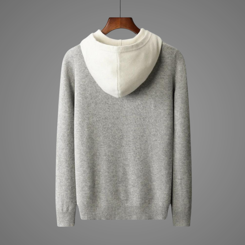 Gray sweater with white hood on a hanger against a gray background