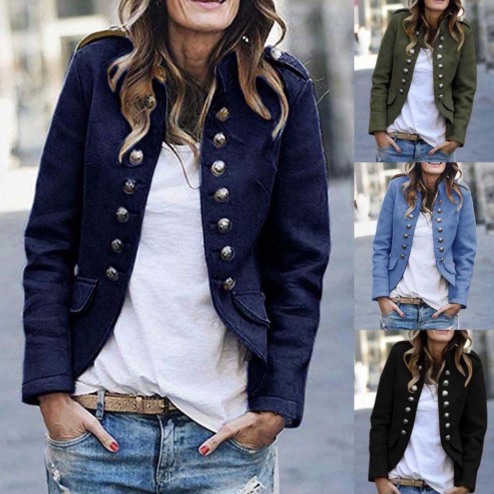 Woman wearing a navy blue jacket with silver buttons, white shirt, and jeans.
