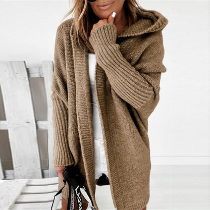 Person wearing a brown knitted cardigan with a white background