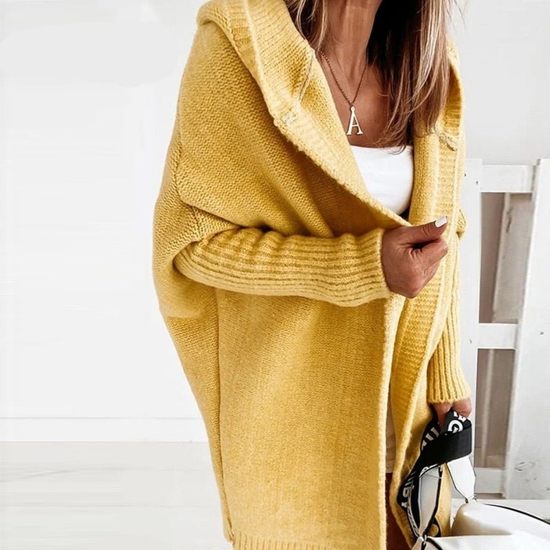 Person wearing a yellow cardigan in a minimal indoor setting