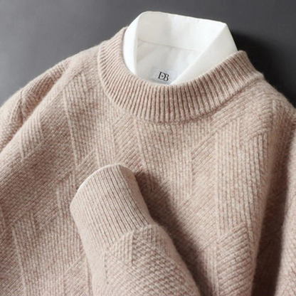 Beige sweater with a brand label on a dark background