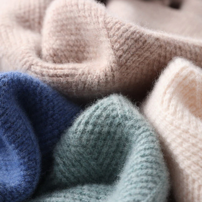 Close-up of knitted yarn in various colors including blue, green, and beige.