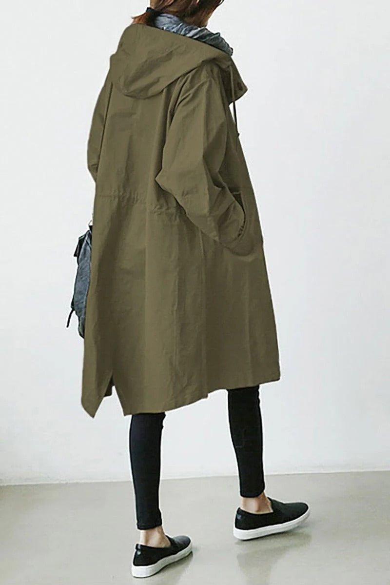 Person wearing a long olive green coat with a hood on a white background