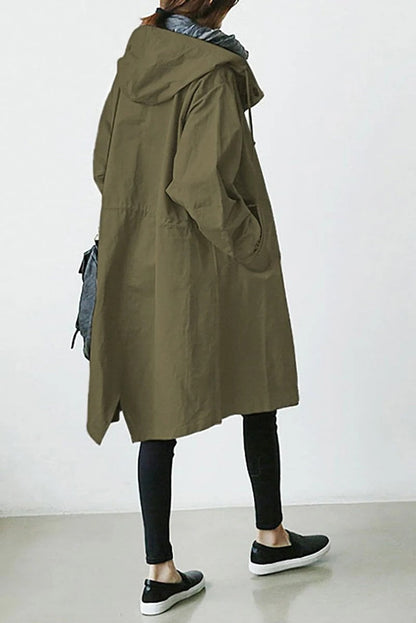 Person wearing a long olive green coat with a hood on a white background