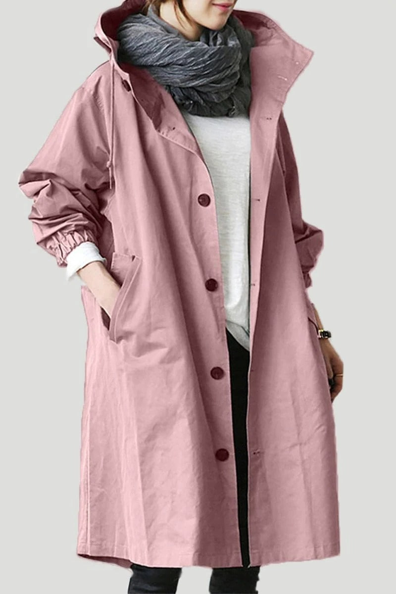 Person wearing a long pink coat with a plain background