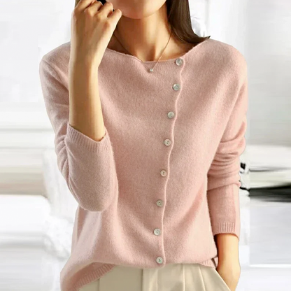 Person wearing a pink cardigan with a blurred background