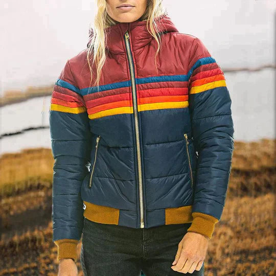 Person wearing a colorful quilted jacket with a blurred natural background