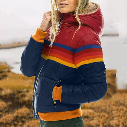 Person wearing a colorful striped puffer jacket with a blurred natural background
