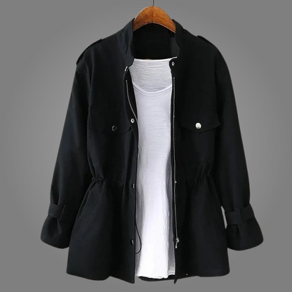 Black coat on a hanger with a white shirt underneath against a gray background