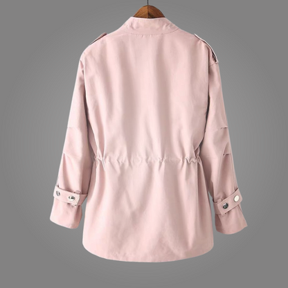 Pink trench coat on a hanger against a gray background