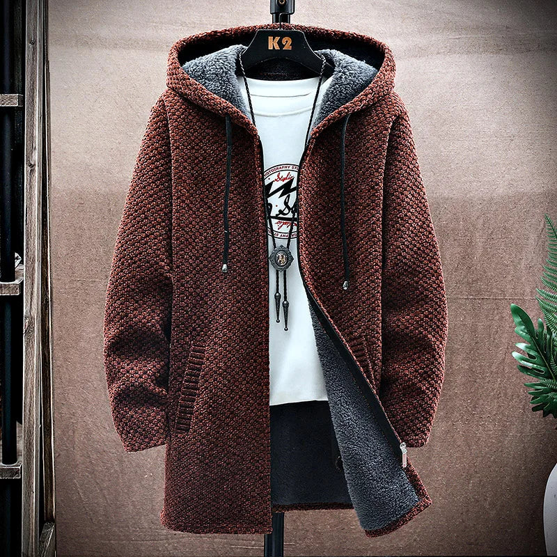 Brown hooded jacket with gray lining on a hanger against a brown wall.