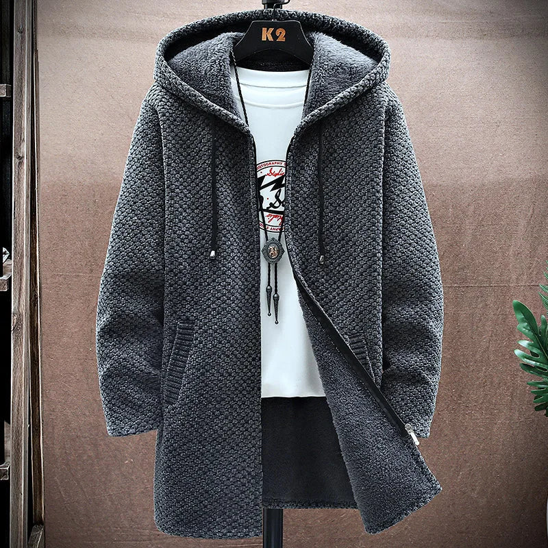 Gray knitted hoodie on a hanger against a brown background